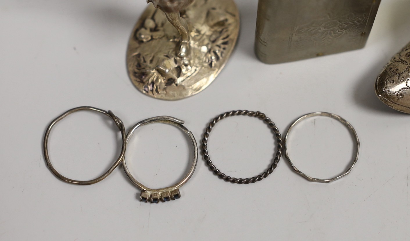 An Edwardian silver miniature model of an occasional chair, import marks for London, 1902, 43mm, a continental white metal model of a shoe and a similar model of a young child, a base metal 'book' box containing a rosary